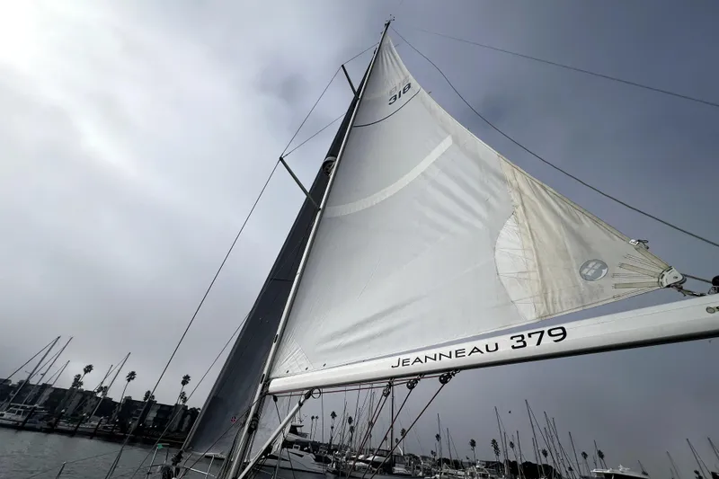 Slide: The Image of Bow view of 2014 Jeanneau Sun Odyssey 379 sailboat docked in calm marina waters. - 16