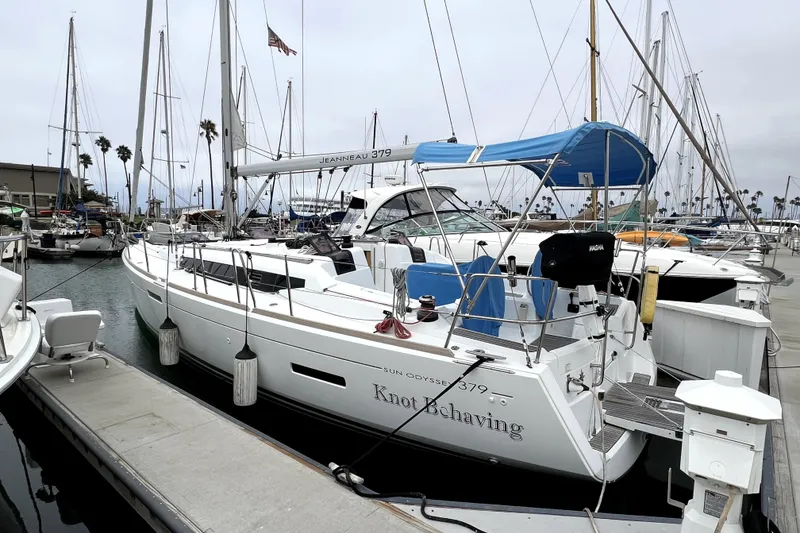 Slide: The Image of 2014 Jeanneau Sun Odyssey 379 sailing in a marina with palm trees and boats. - 18