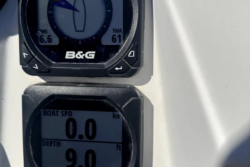 Slide: The Image of 2014 Jeanneau Sun Odyssey 379 sailboat docked in marina, featuring blue canopy and sleek design. - 22