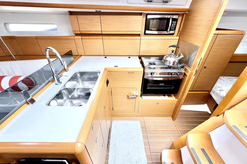Slide: The Image of Interior of 2014 Jeanneau Sun Odyssey 379 sailboat with modern kitchen and seating area. - 33