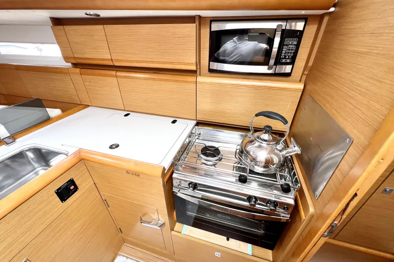 Slide: The Image of Interior of 2014 Jeanneau Sun Odyssey 379 sailboat with modern wood finish and white seating. - 34
