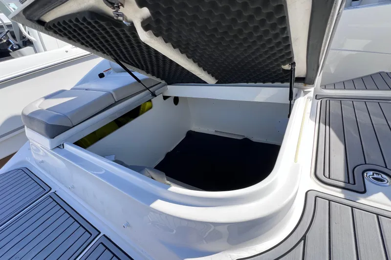 Slide: The Image of 2021 Sea Ray SDX 270 Outboard boat storage compartment with cushioned seating. - 15