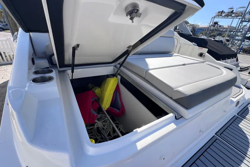 Slide: The Image of 2021 Sea Ray SDX 270 Outboard boat with open storage compartment and life jackets. - 16