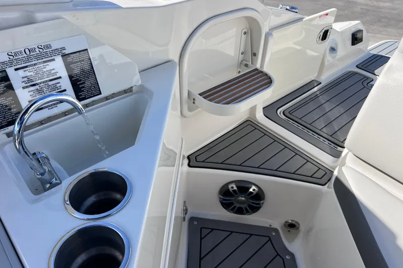 Slide: The Image of 2021 Sea Ray SDX 270 Outboard boat interior with sink, cup holders, and seating area. - 17