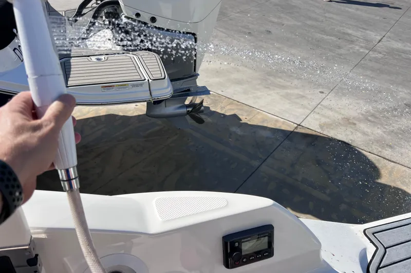 Slide: The Image of Hand holding a hose on a 2021 Sea Ray SDX 270 Outboard boat deck. - 18