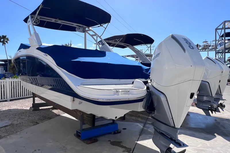 Slide: The Image of 2021 Sea Ray SDX 270 Outboard boat with blue cover and twin Mercury engines. - 2