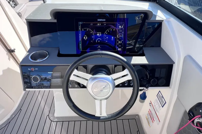 Slide: The Image of 2021 Sea Ray SDX 270 Outboard dashboard with steering wheel and digital display. - 29