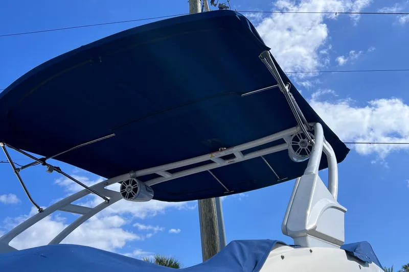 Slide: The Image of 2021 Sea Ray SDX 270 Outboard boat with blue canopy against a clear sky. - 5