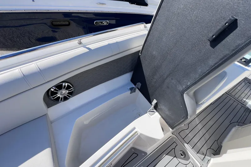 Slide: The Image of 2021 Sea Ray SDX 270 Outboard interior with open storage compartment and speaker. - 51