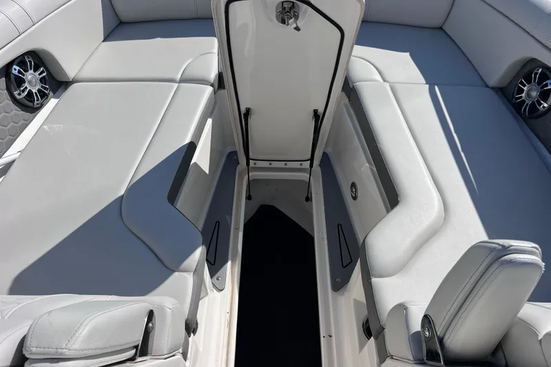 Slide: The Image of 2021 Sea Ray SDX 270 Outboard interior with open storage compartment and cushioned seating. - 53
