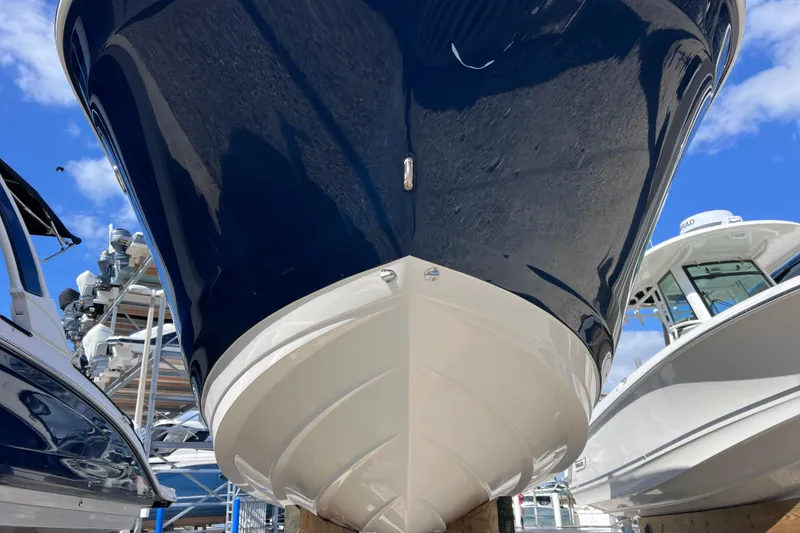 Slide: The Image of 2021 Sea Ray SDX 270 Outboard boat hull, blue and white, docked under clear sky. - 6