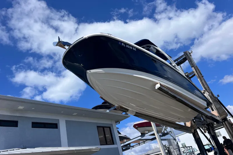 Slide: The Image of 2021 Sea Ray SDX 270 Outboard boat lifted against blue sky background. - 7