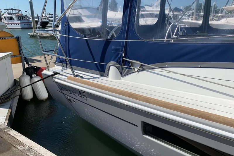 Slide: The Image of 2018 Beneteau Oceanis 45 sailboat docked with blue canopy and fenders. - 14