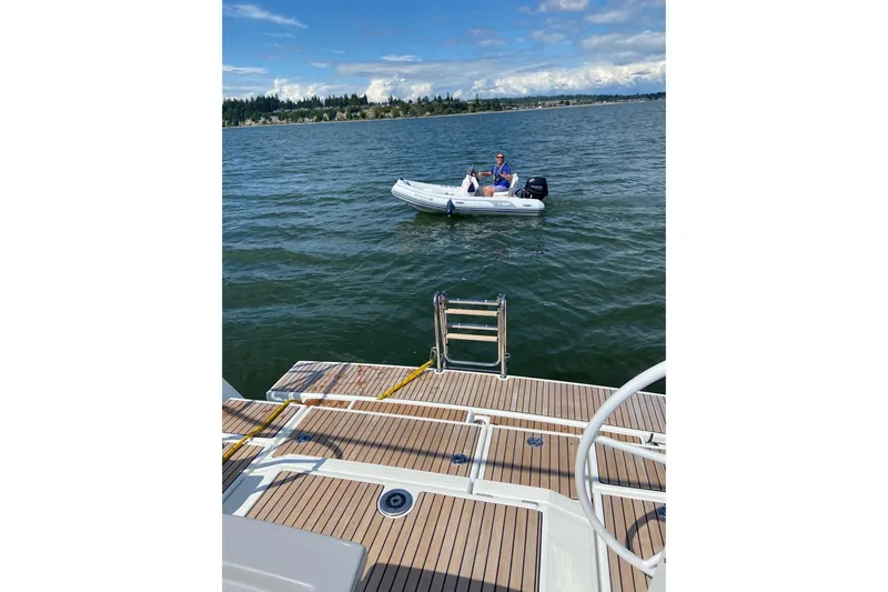 Slide: The Image of Beneteau Oceanis 45 yacht deck with person in dinghy on water, 2018 model. - 19