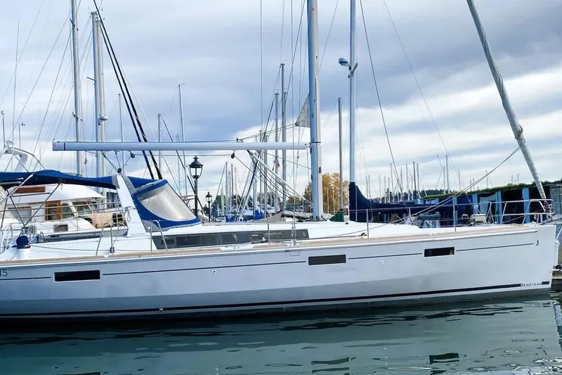 Slide: The Image of 2018 Beneteau Oceanis 45 sailboat docked in a marina under cloudy skies. - 2