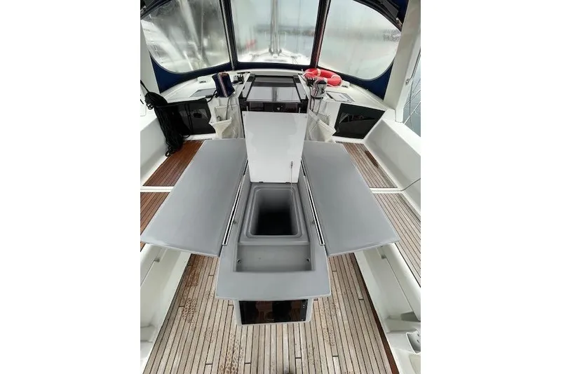 Slide: The Image of 2018 Beneteau Oceanis 45 yacht cockpit with foldable table and sink, featuring teak flooring. - 26