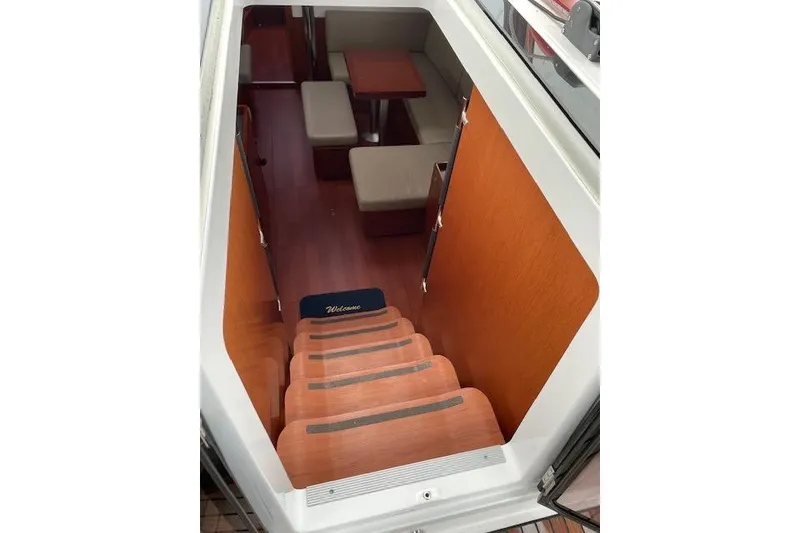 Slide: The Image of Interior view of 2018 Beneteau Oceanis 45 yacht, featuring wooden stairs and cozy seating area. - 28