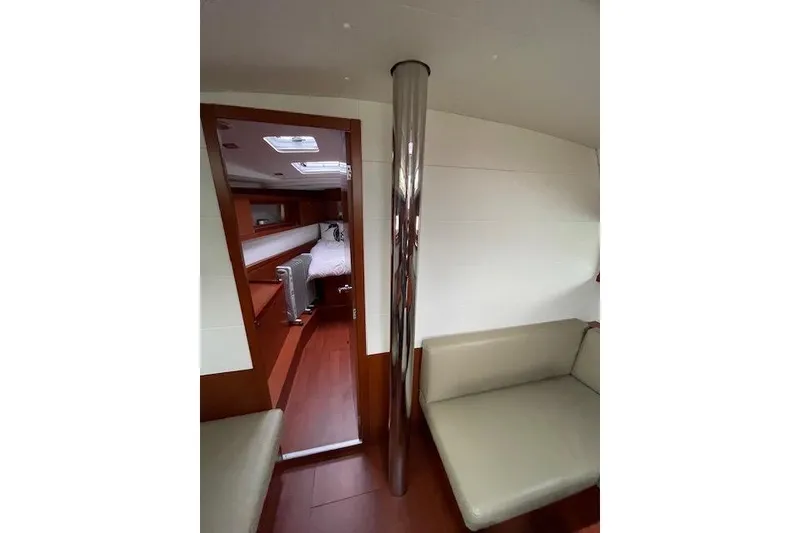 Slide: The Image of Interior of 2018 Beneteau Oceanis 45 yacht, featuring cozy seating and a cabin view. - 39