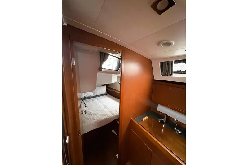 Slide: The Image of 2018 Beneteau Oceanis 45 interior cabin with bed and wooden cabinetry. - 44
