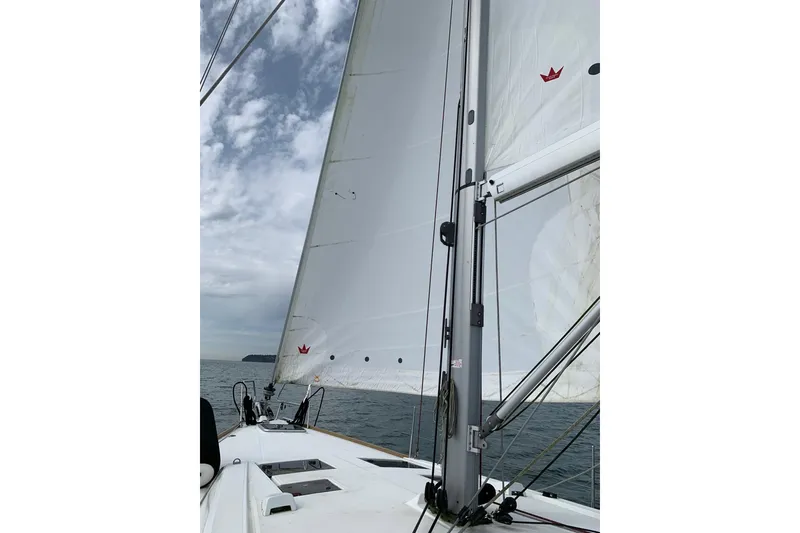 Slide: The Image of Sailing on a 2018 Beneteau Oceanis 45 with white sails against a cloudy sky. - 6