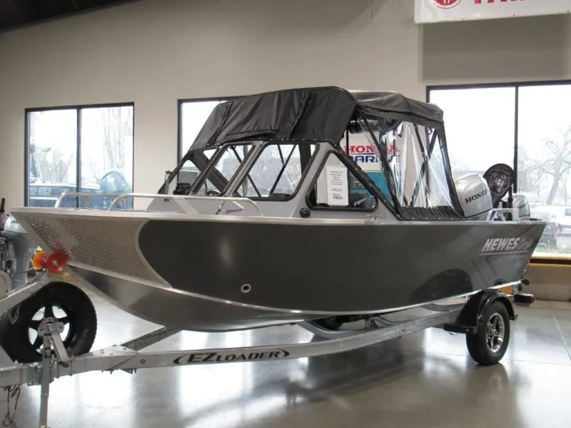 The Image of 2026 Hewescraft 180 Sportsman boat on trailer in showroom. - 1