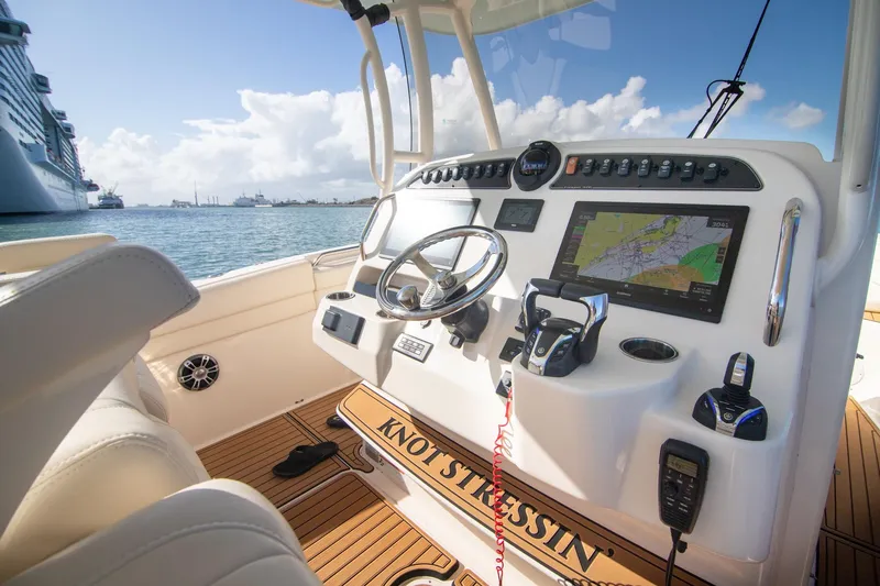 Slide: The Image of 2023 Grady-White Canyon 326 boat dashboard with navigation system, steering wheel, and controls. - 14