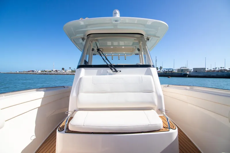 Slide: The Image of 2023 Grady-White Canyon 326 boat on calm water, showcasing sleek design and spacious seating. - 19