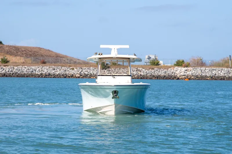 Slide: The Image of 2023 Grady-White Canyon 326 boat cruising on a calm blue waterway. - 2