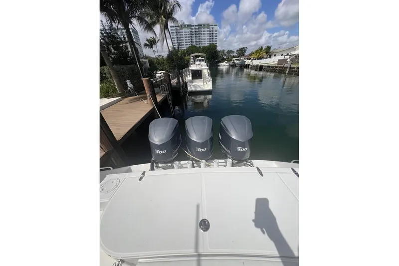 Slide: The Image of 2014 Stamas 390 Tarpon with triple 300 horsepower engines docked by palm trees. - 6