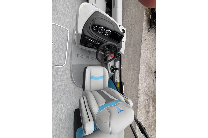 Slide: The Image of 2026 Trifecta C Series 24RFC CS boat interior with steering console and seating. - 11
