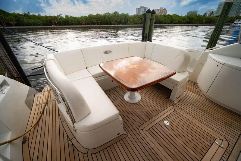 Slide: The Image of Luxurious 2007 Pershing 62' yacht deck with elegant seating and wooden table. - 34