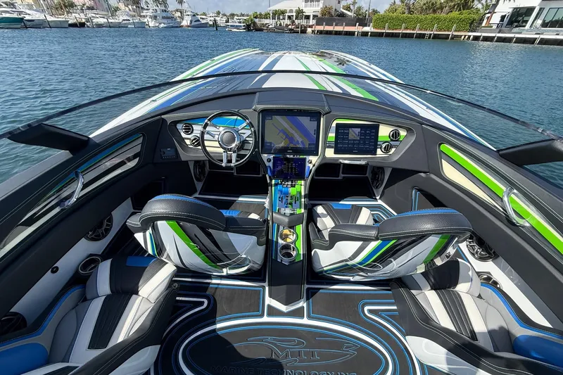 Slide: The Image of Interior view of 2022 MTI 390X boat with modern dashboard and seating. - 11
