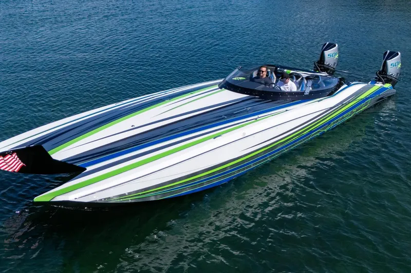 Slide: The Image of 2022 MTI 390X powerboat with vibrant stripes on water, featuring dual engines. - 29