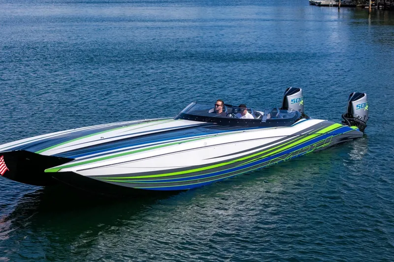 Slide: The Image of 2022 MTI 390X powerboat with vibrant stripes on calm water. - 30