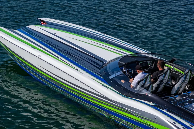 Slide: The Image of 2022 MTI 390X speedboat with vibrant stripes cruising on clear blue water. - 35