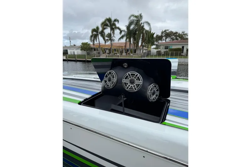 Slide: The Image of 2022 MTI 390X boat with sleek design, vibrant colors, and powerful speakers docked by a canal. - 41