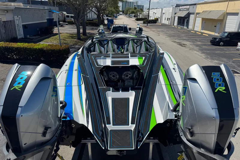 Slide: The Image of 2022 MTI 390X powerboat on trailer, vibrant stripes, parked near industrial buildings. - 48