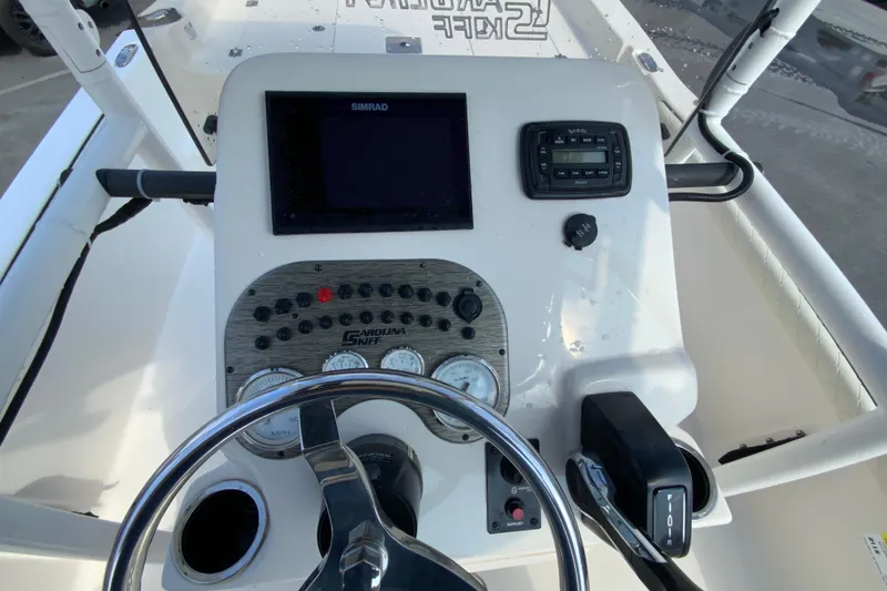 Slide: The Image of 2021 Carolina Skiff 21 LS boat dashboard with steering wheel and control panel. - 12