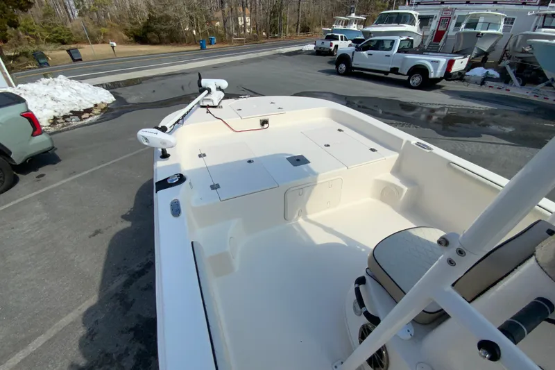 Slide: The Image of 2021 Carolina Skiff 21 LS boat with spacious deck and seating, parked outdoors. - 13