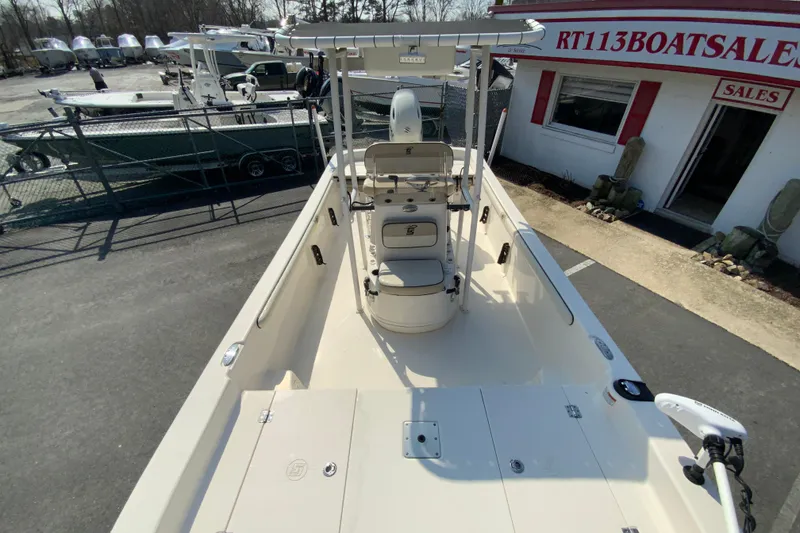 Slide: The Image of 2021 Carolina Skiff 21 LS boat at dealership, showcasing spacious deck and seating. - 17