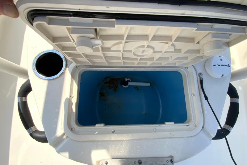 Slide: The Image of Open storage compartment on 2021 Carolina Skiff 21 LS boat, featuring a blue interior. - 18