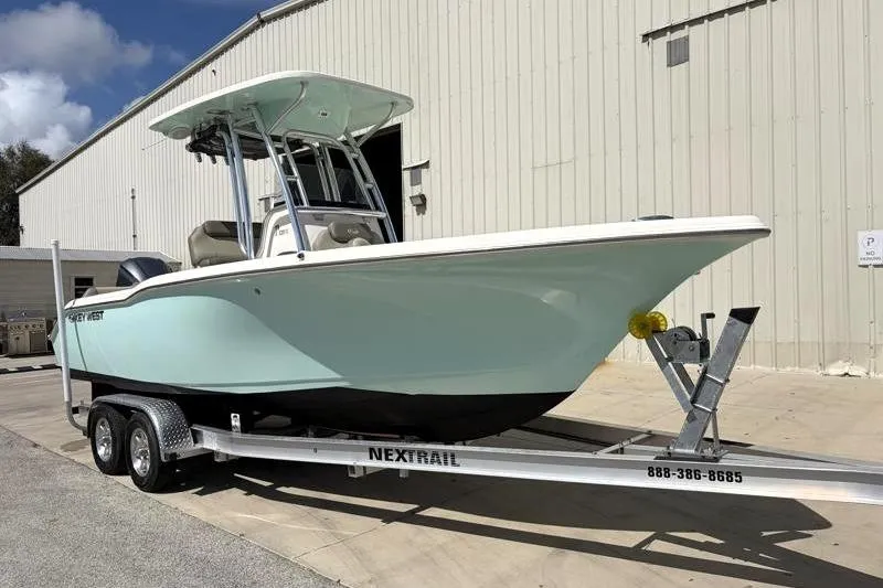 The Image of 2024 Key West 239 FS boat on trailer, parked outside a large building. - 1