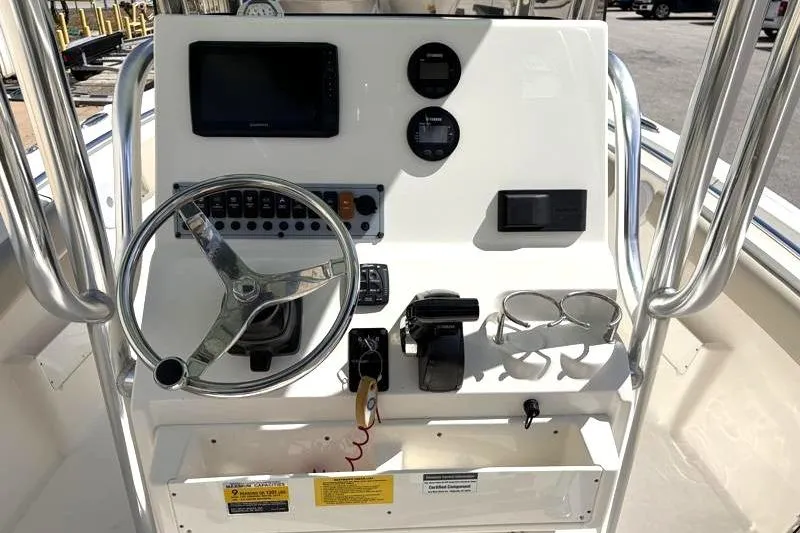 Slide: The Image of 2024 Key West 239 FS boat console with steering wheel, gauges, and controls. - 25