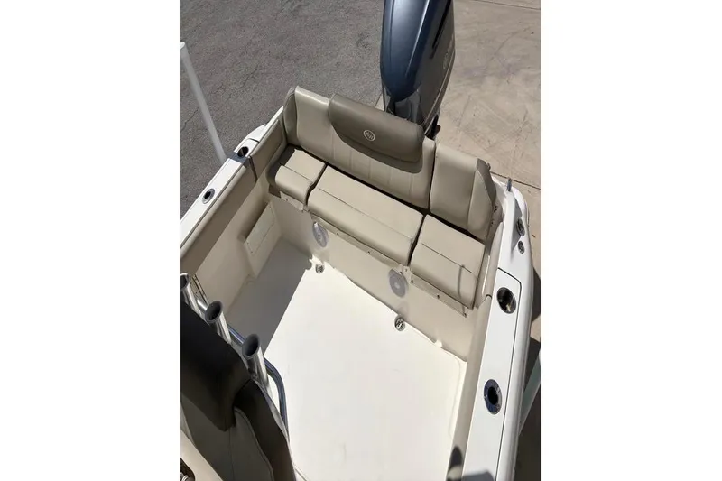 Slide: The Image of 2024 Key West 239 FS boat interior with beige seating and motor view. - 32