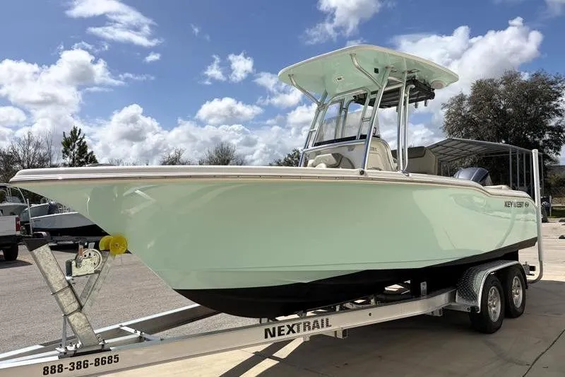 Slide: The Image of 2024 Key West 239 FS boat on trailer under a partly cloudy sky. - 4
