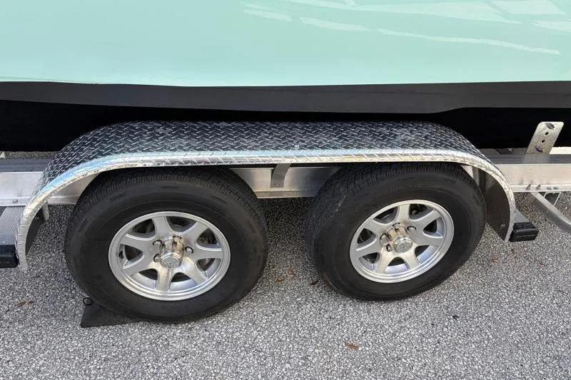 Slide: The Image of Trailer wheels of a 2024 Key West 239 FS boat on a textured surface. - 42