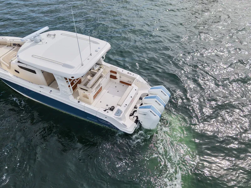 Slide: The Image of A 2027 Boston Whaler 350 Realm on the water with three outboard engines. - 34