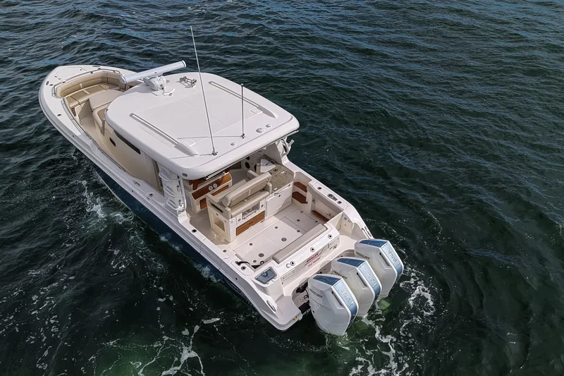 Slide: The Image of A 2027 Boston Whaler 350 Realm on the water with three outboard engines. - 33