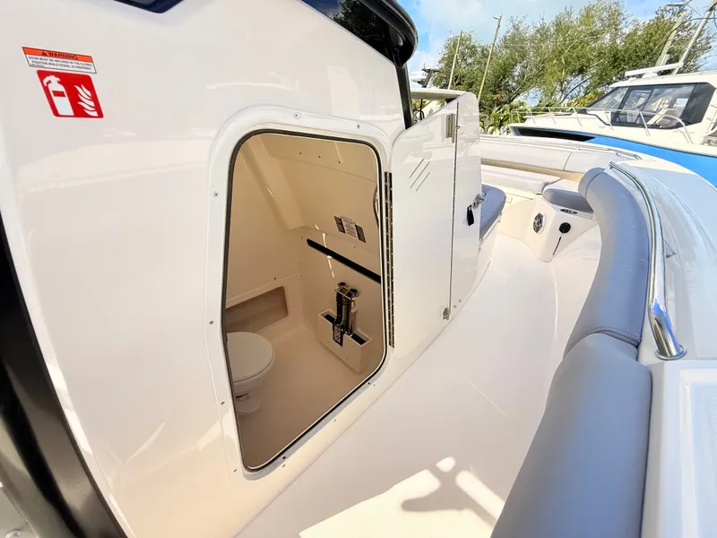 Slide: The Image of Interior view of a Boston Whaler 280 Outrage with a small toilet and seating area. - 43