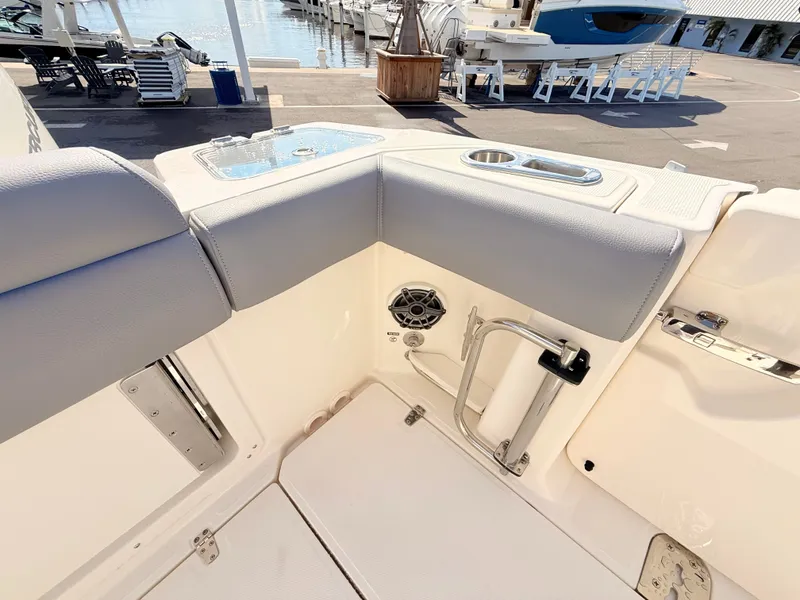 Slide: The Image of The 2026 Boston Whaler 280 Outrage features a well-equipped corner with a speaker and cup holder. - 17
